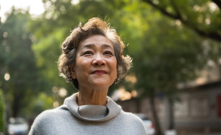 older asian woman smiling looking while looking forward