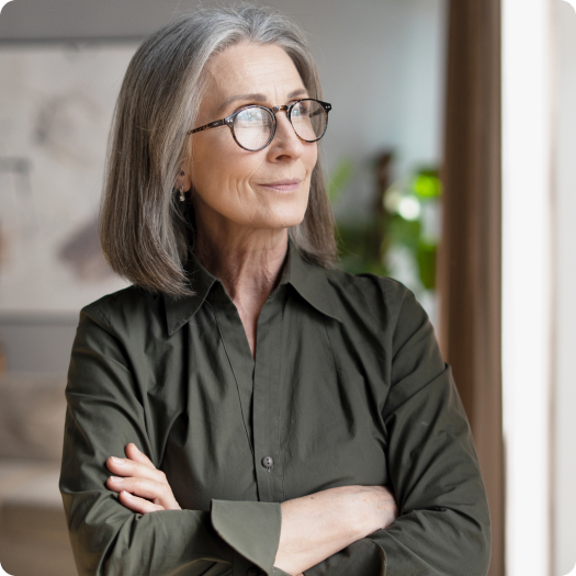 Older woman in olive shirt standing indoors