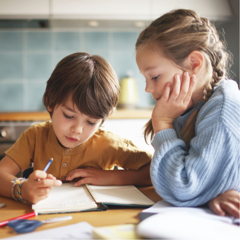 Children doing homework together at table