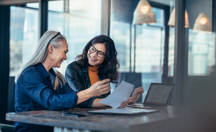 Women sitting at a table looking at documents