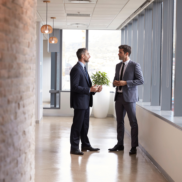 two men in suits talking in an office