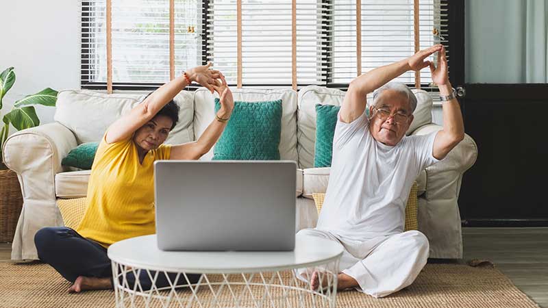 Couple stretching in front of laptop