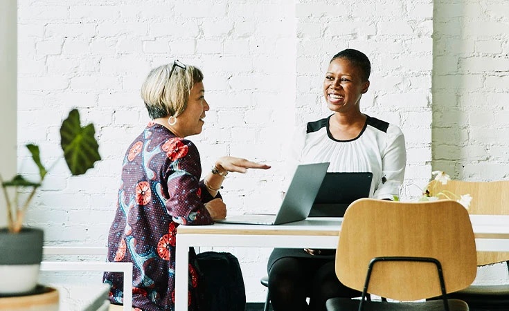 Women discussing over a laptop