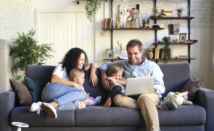 Family on couch looking at laptop