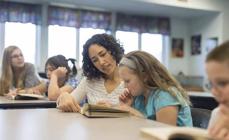 Female teacher guiding students in classroom setting
