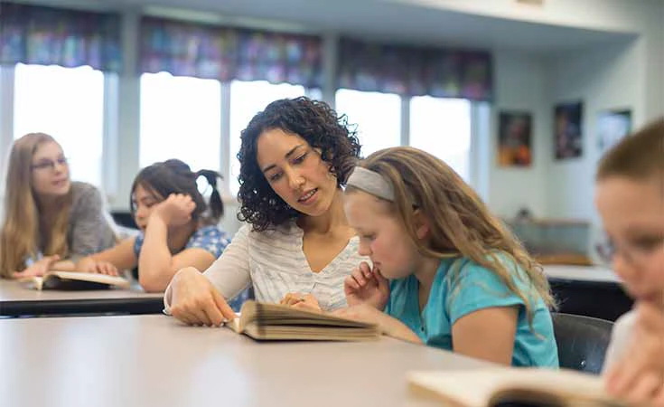 Teacher working with a student at a desk