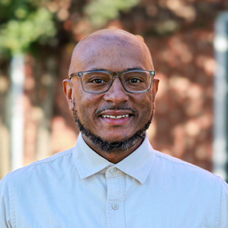 male educator smiling outside