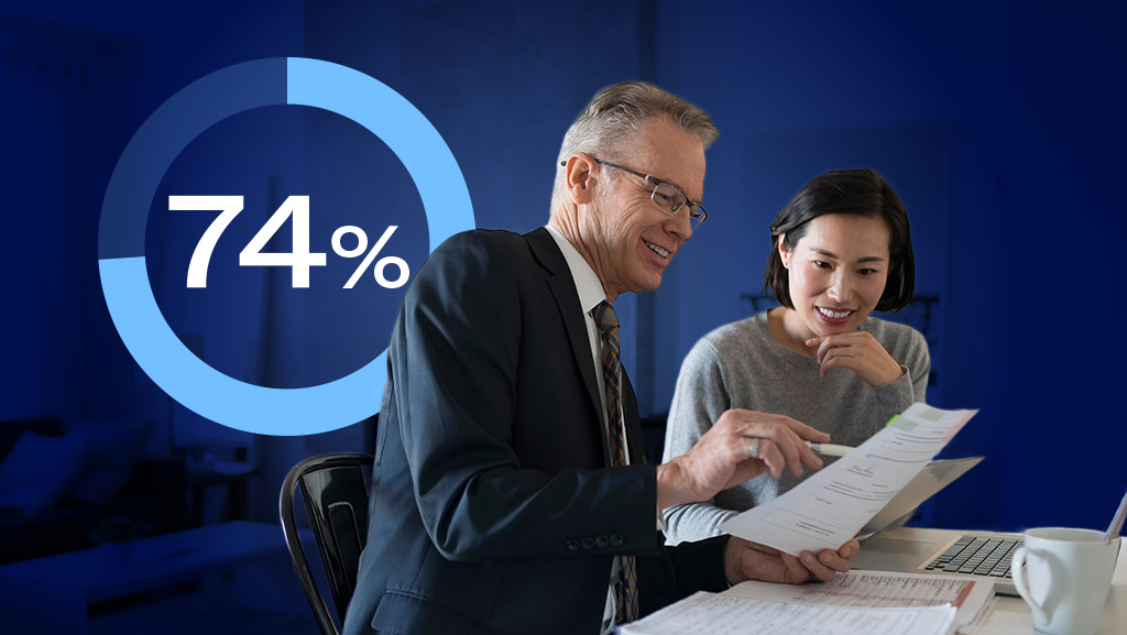 Business colleagues reviewing financial report together with 74% graphic in background