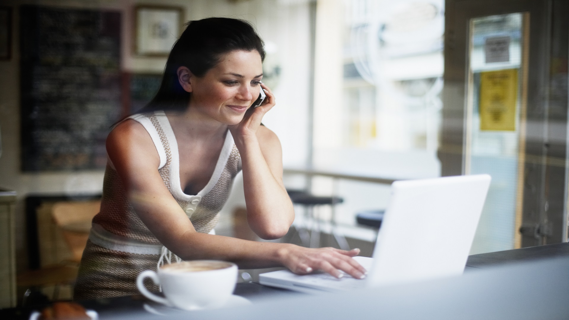Woman sitting at a table looking at a computer